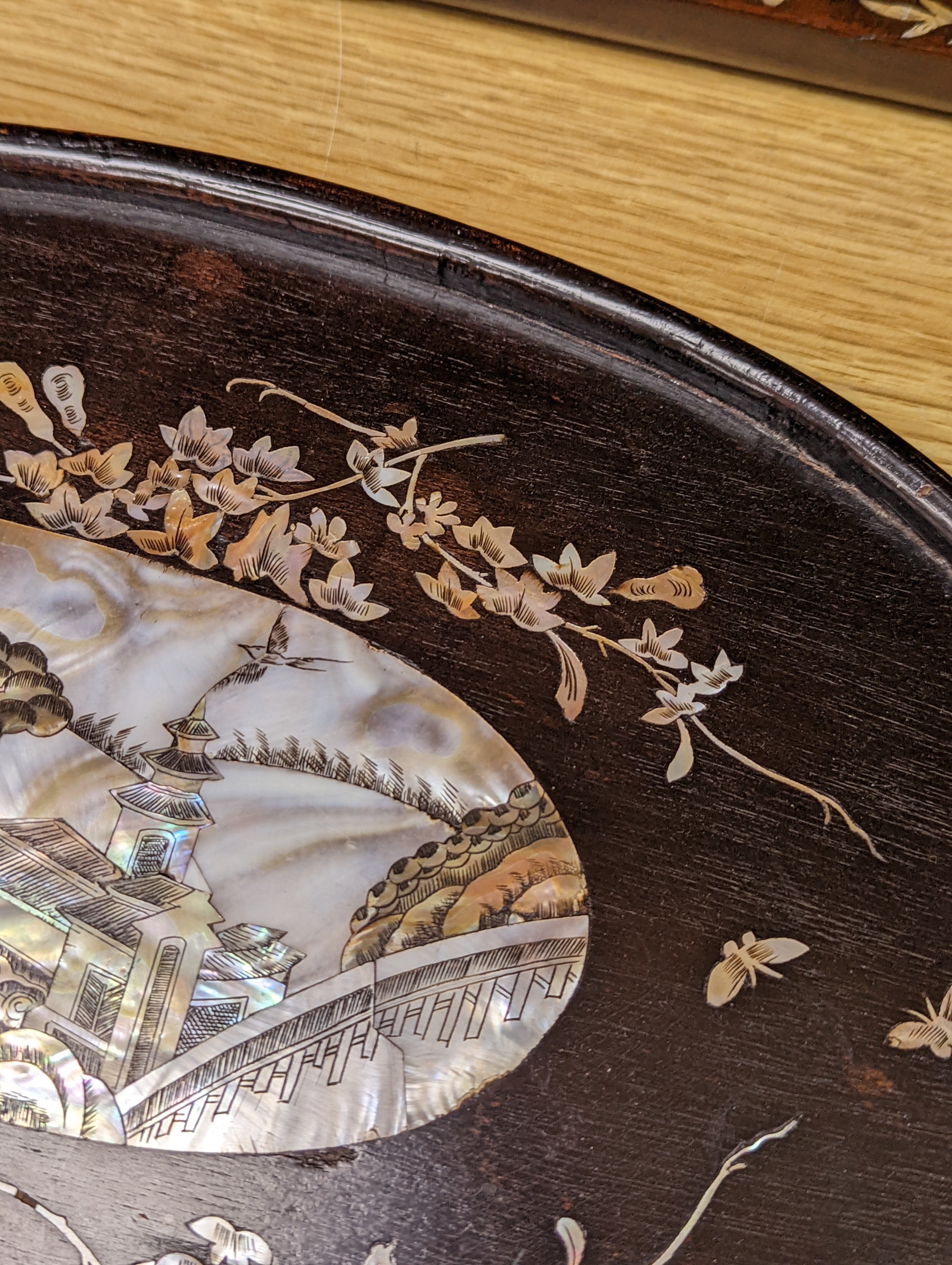 Two Chinese mother of pearl inlaid hongmu trays, the rectangular example with birds and insects amid flowers and the smaller oval example with a pavilion in a landscape within floral sprays 55x34cm